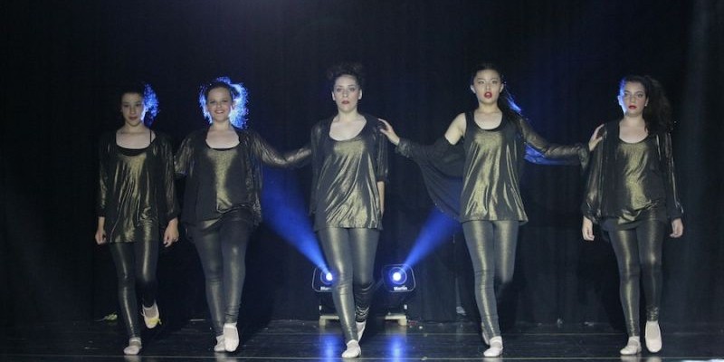 Five young girls performing at a dance concert