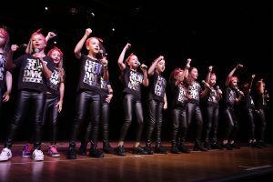 Young girls in black RUN DMC t-shirts, sing and dance
